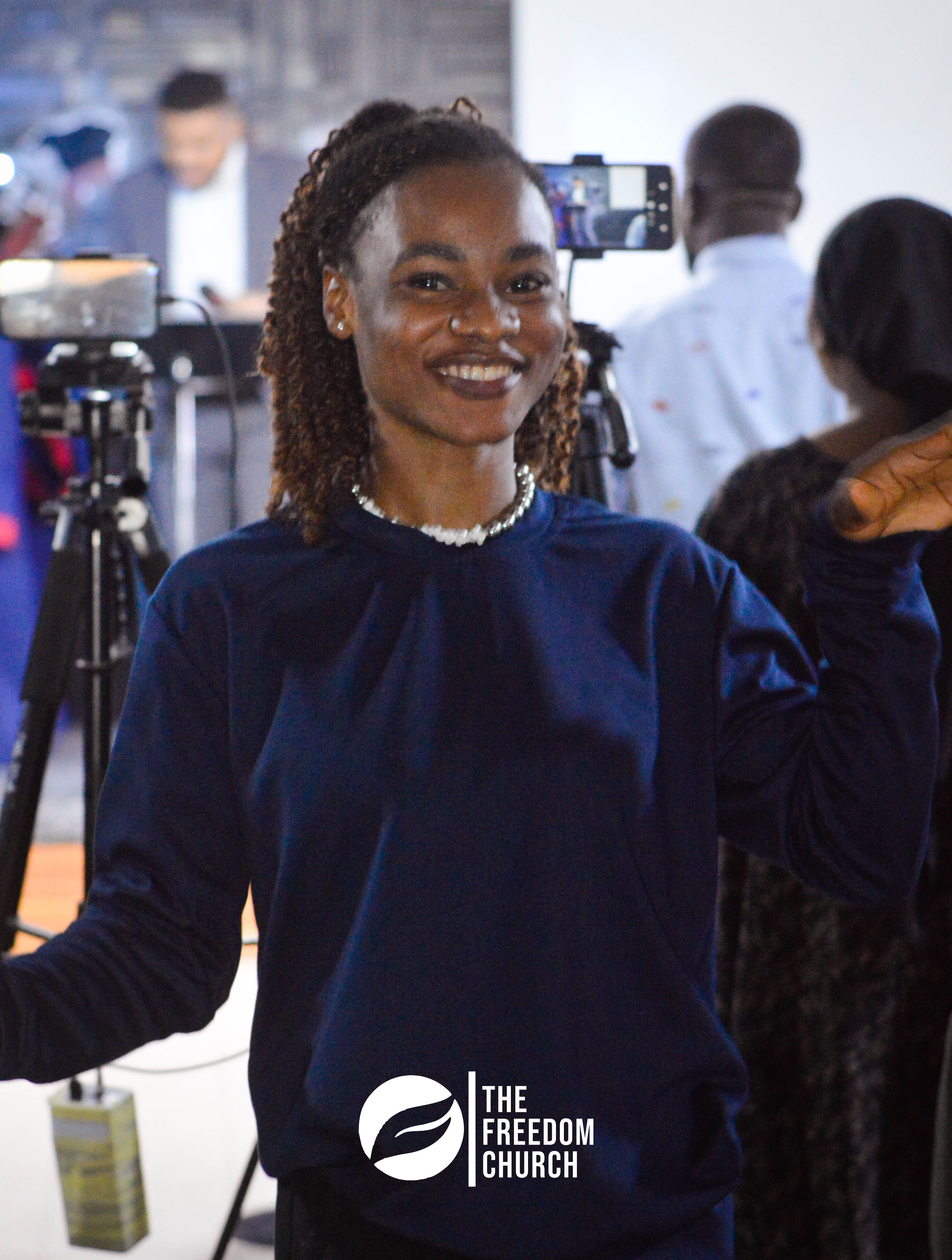 A member smiling near the cameras at Freedom Church